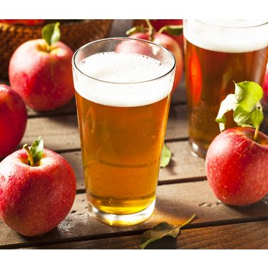 Glass of hard cider with apples