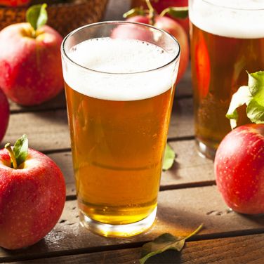 Glass of hard cider with apples