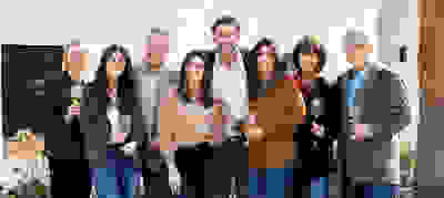 A group of people smiling together with wine glasses