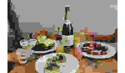dining at a table with bottle of wine