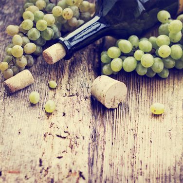 White grapes with a bottle on a table