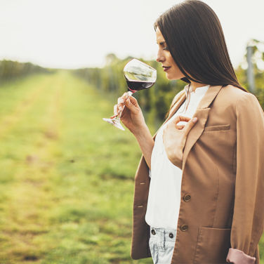 Woman drinking wine in a vineyard