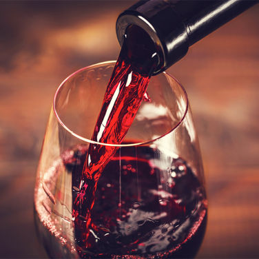 Bottle of red wine being poured into a glass