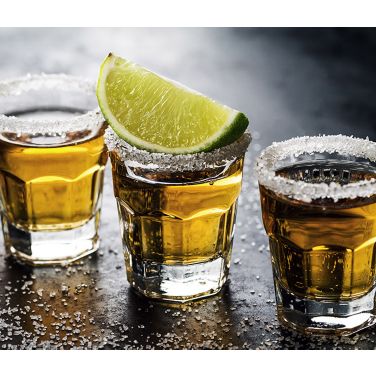 Three shots of tequila with lime and salt