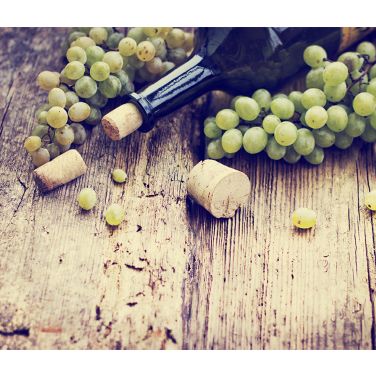 White grapes with a bottle on a table